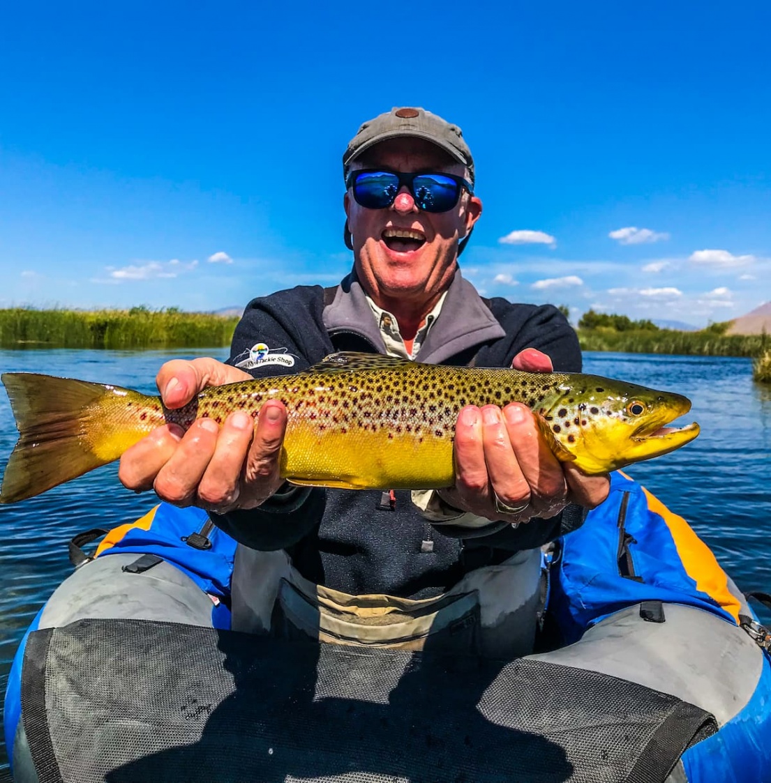 Man on Silver Creek holding a big brown